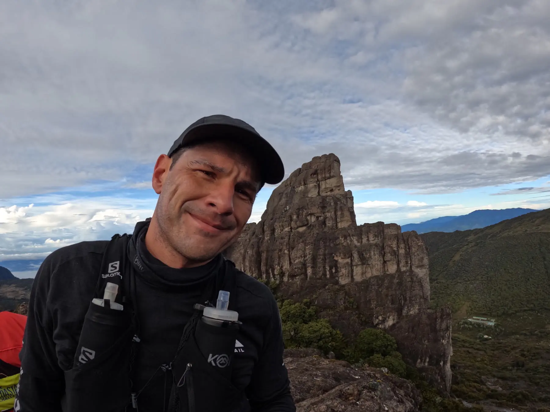 El Dr. JC Arias en la cima de una montaña al amanecer.